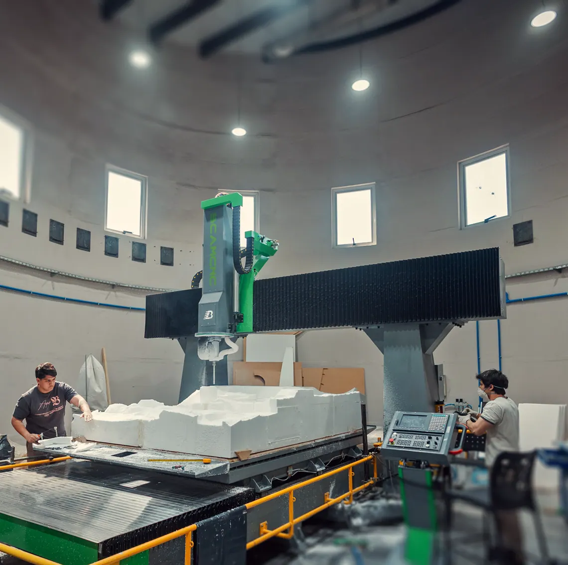 Taller de Forma Lab: dos técnicos junto a una fresadora CNC que talla un bloque de telgopor